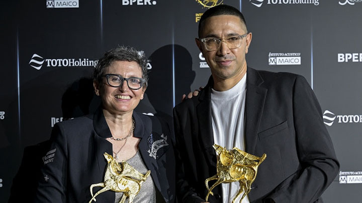 a woman and man hold awards